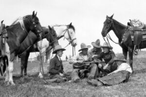 Five Cowboys playing and singing to their horses